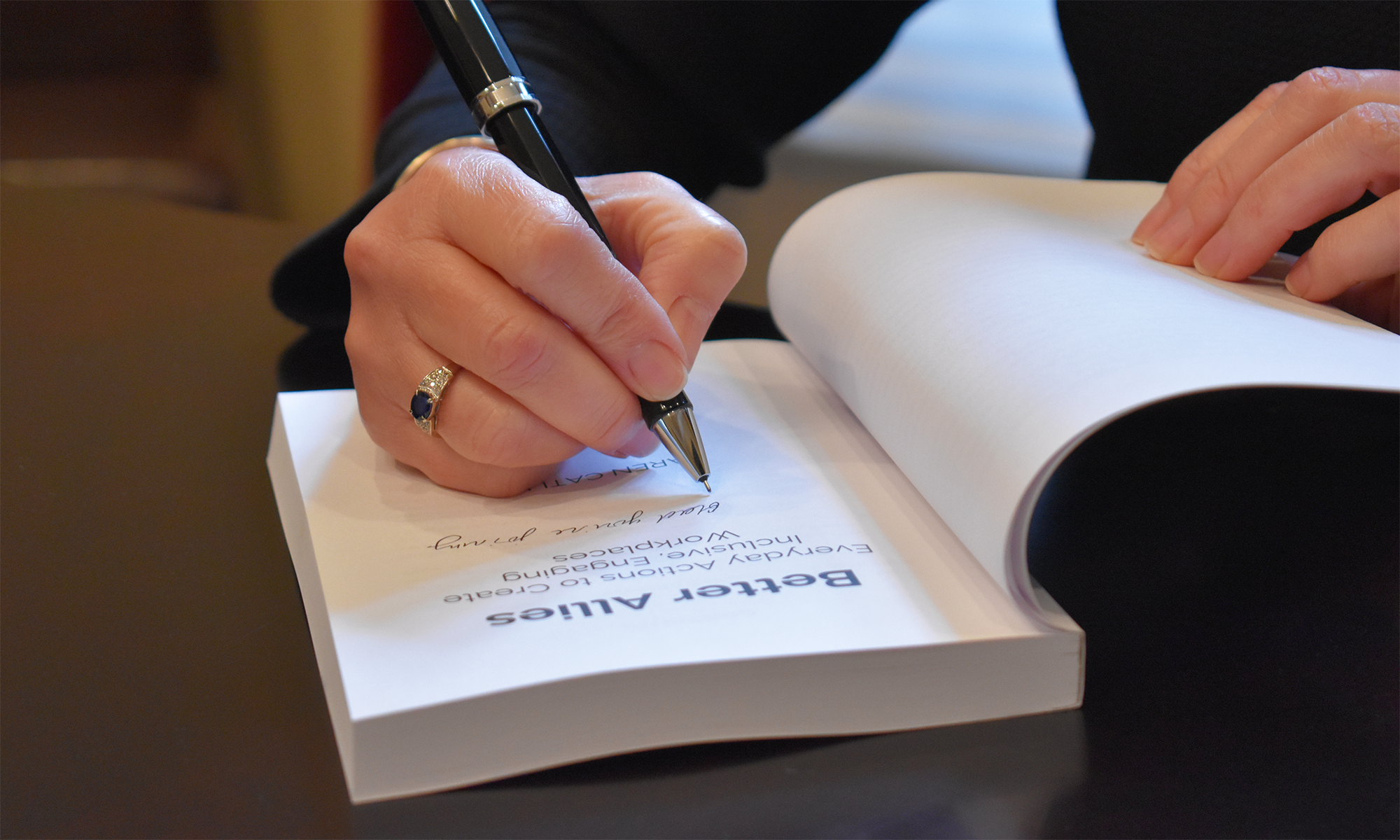 Photo of Karen Catlin signing the Better Allies book